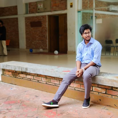 ইটের ভবনের সামনে বেঞ্চে বসে থাকা শিপু